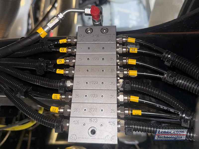 ILC DPX lubrication divider valve with labeled tail lines connected to each outlet.
